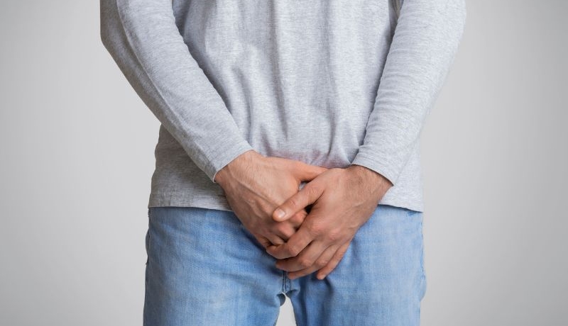 Rak pęcherza moczowego – objawy, diagnoza i leczenie. Na zdjęciu mężczyzna trzyma dłonie w okolicach pęcherza.